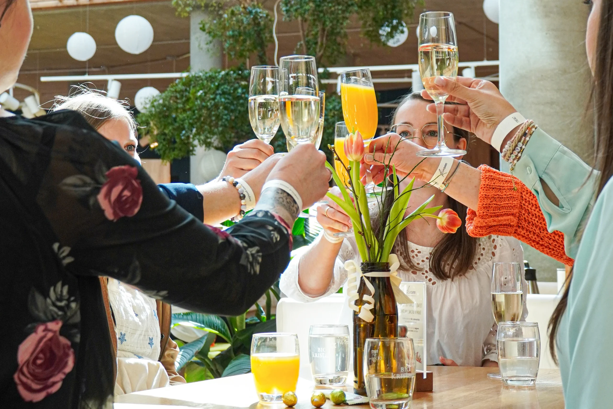 Kundinnen stoßen beim Frühstück mit Sekt an