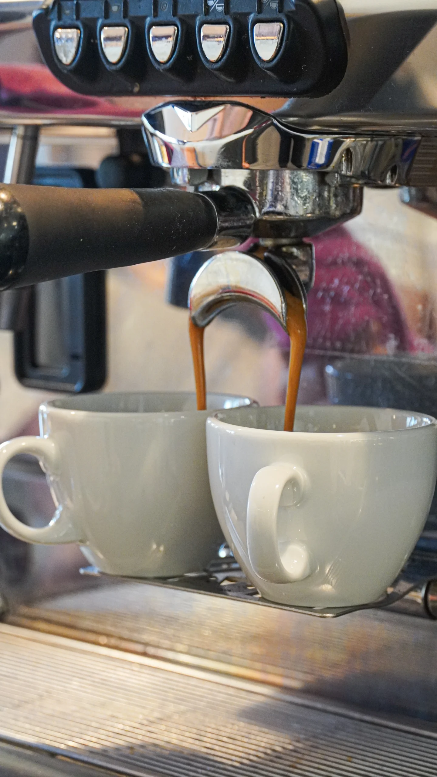 Kaffee läuft aus einer Siebträgermaschine in zwei Tassen