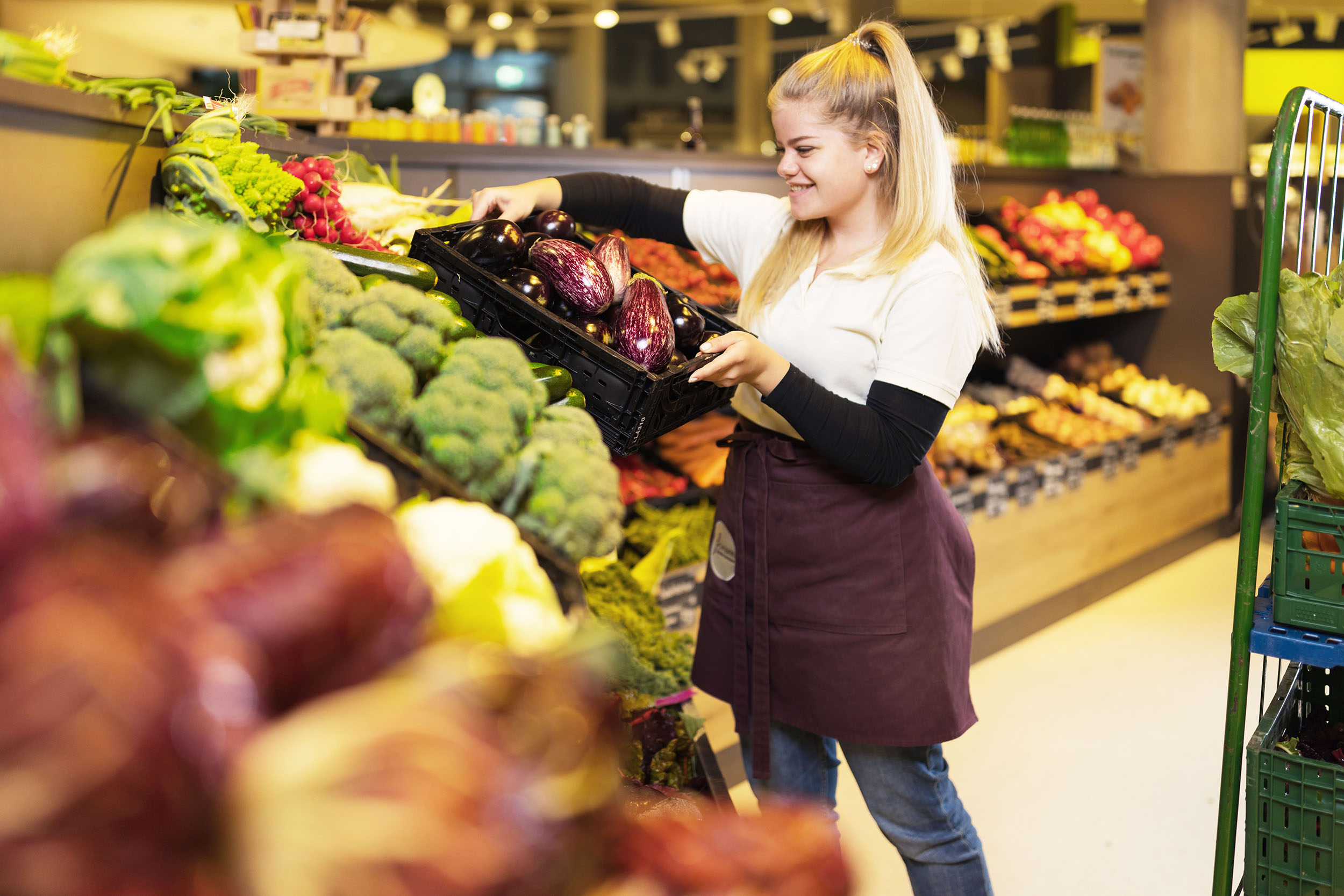 Feinsinn Mitarbeiterin räumt Gemüse ein