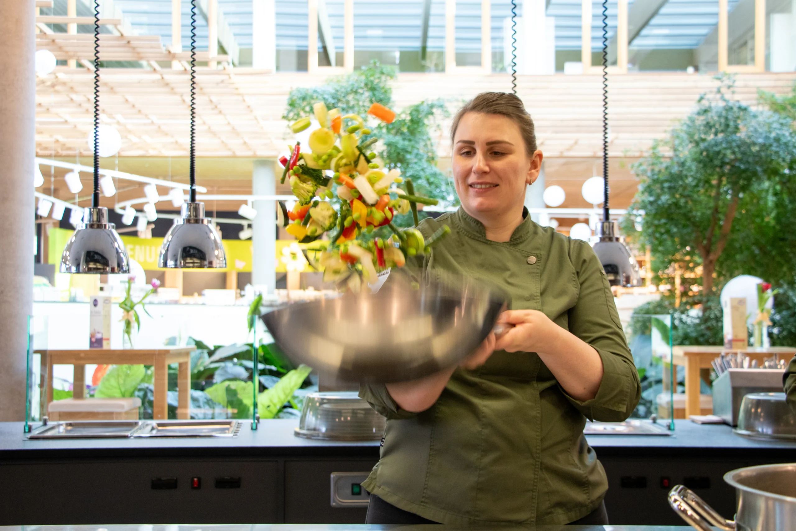 Köchin schleudert Essen kunstvoll in der Pfanne